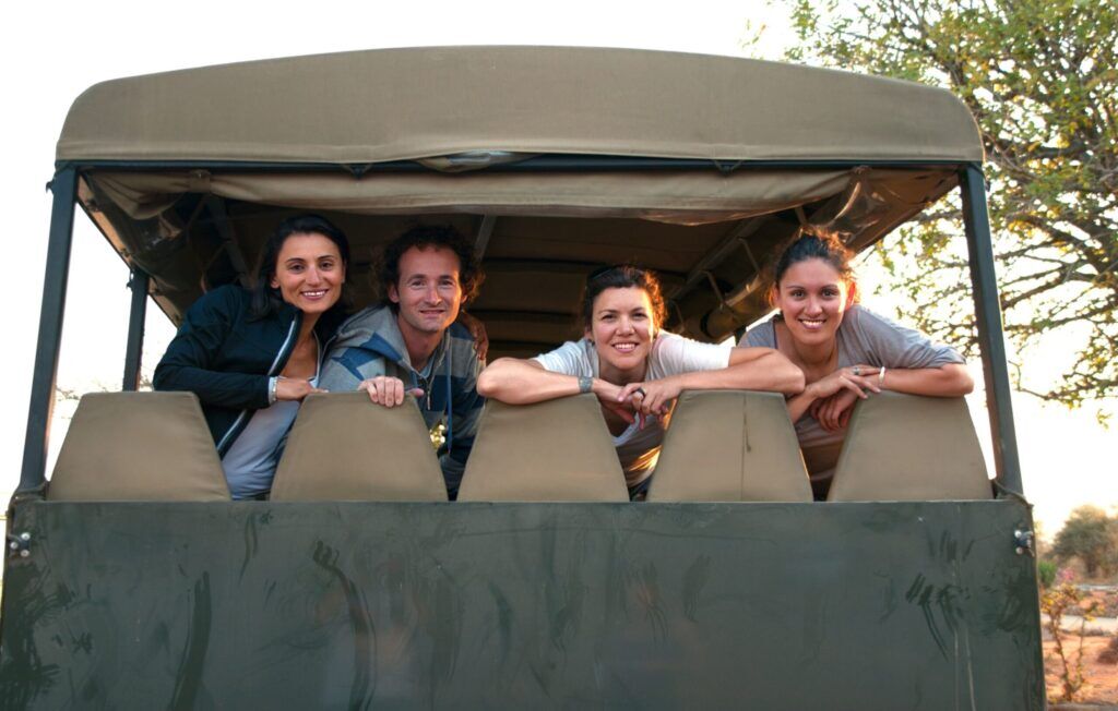 Safari jeep with four people looking out at the back