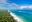 White sandy Diani Beach with trees on one side and the blue sea on the other