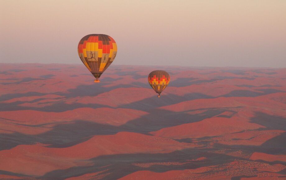 Two hot air balloons during sunrise above the Namib desert