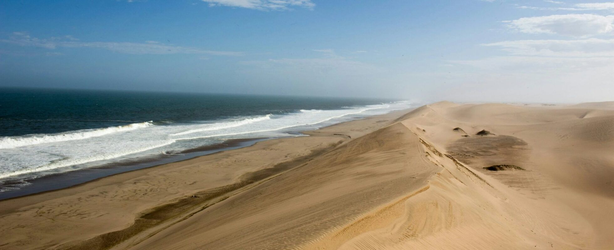 High yellow sand dunes of Sandwich harbour with the sea right next to it