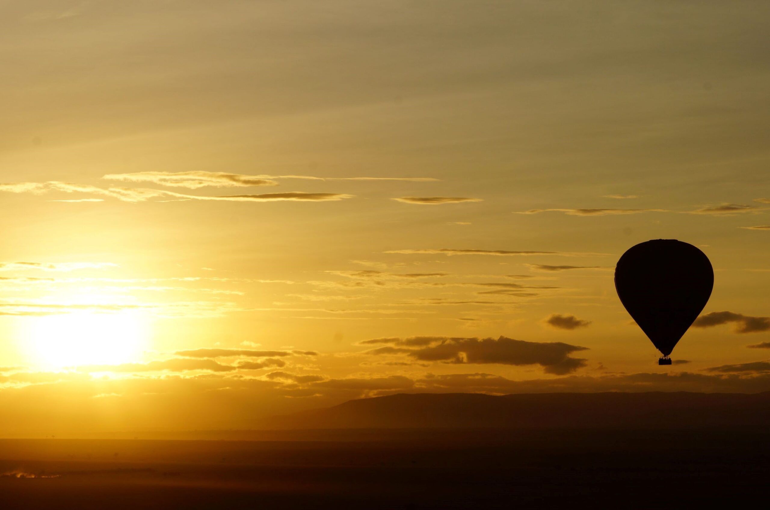 Hot air balloon flying over the Masai Mara during sunset