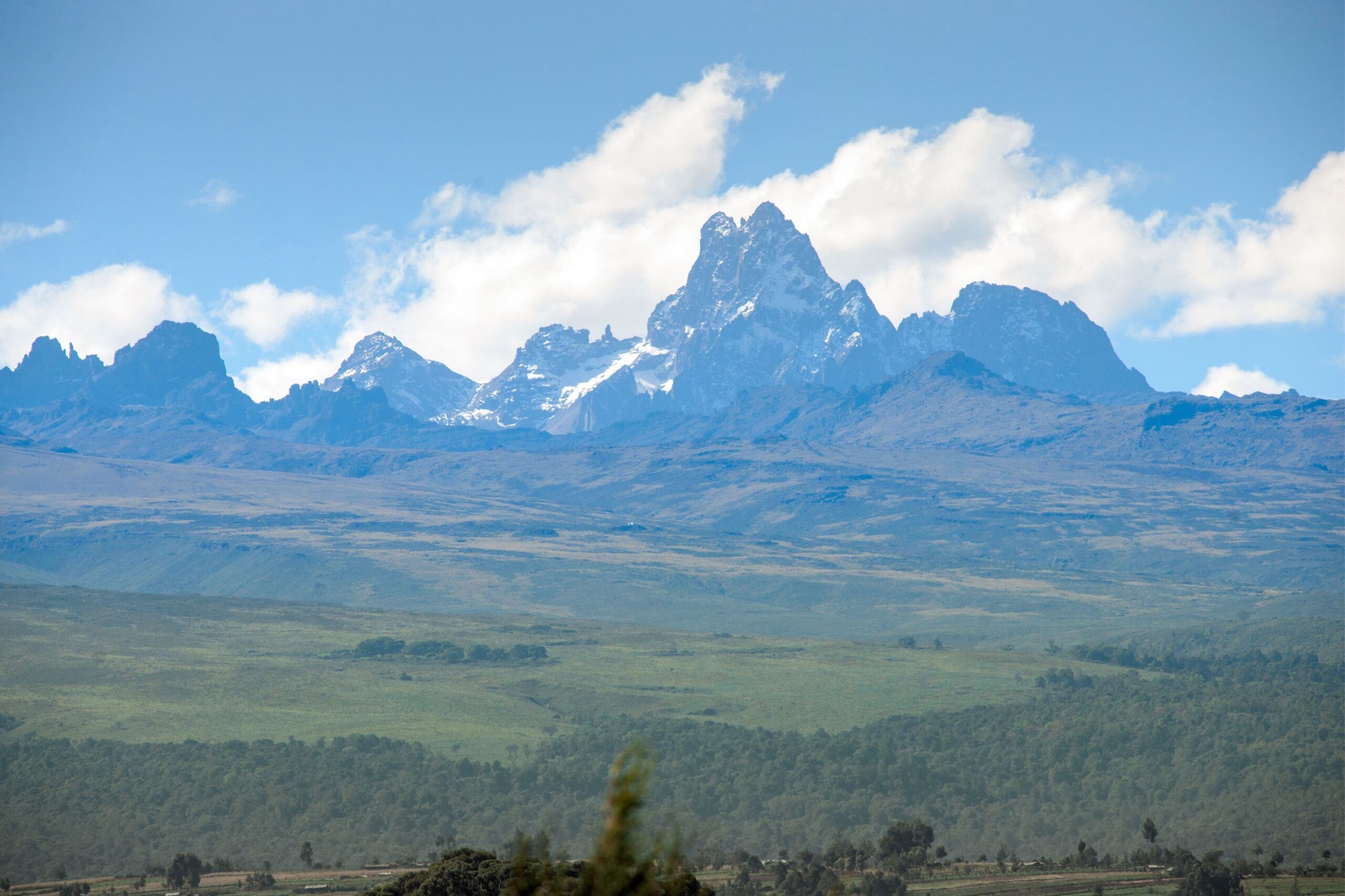 Mount Kenya from a distance with green landscape in front of it