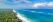 White sandy Diani Beach with trees on one side and the blue sea on the other