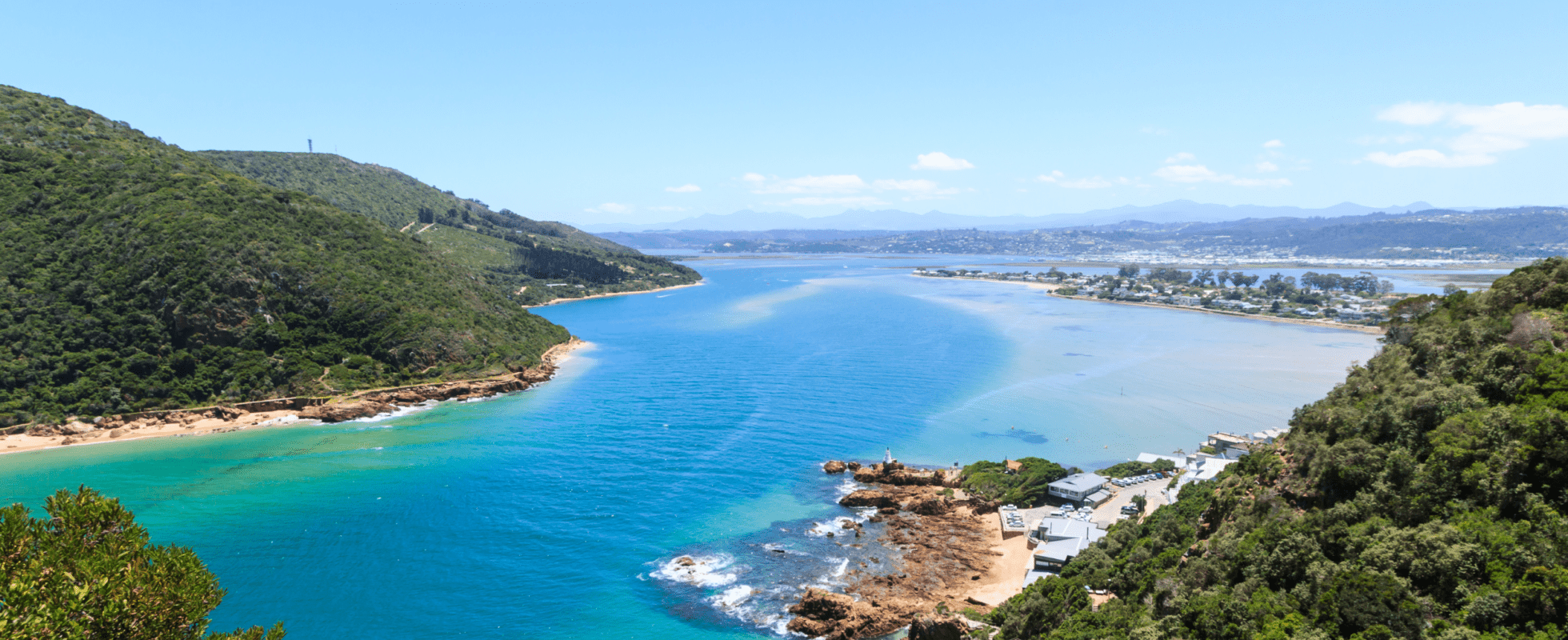 View of the turquoise Knysna Lagoon surrounded by forested hills along South Africa’s Garden Route.